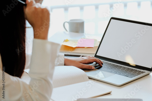 Young business woman working in office with laptop computer and financial documents