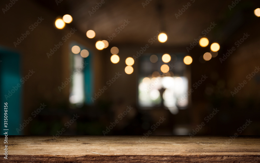 Empty wood table top on blur light gold bokeh of cafe restaurant in dark background Empty wood table top on blur light gold bokeh of cafe restaurant in dark background