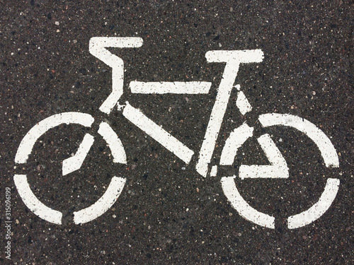 Sign "bike path" on wet asphalt. White paint