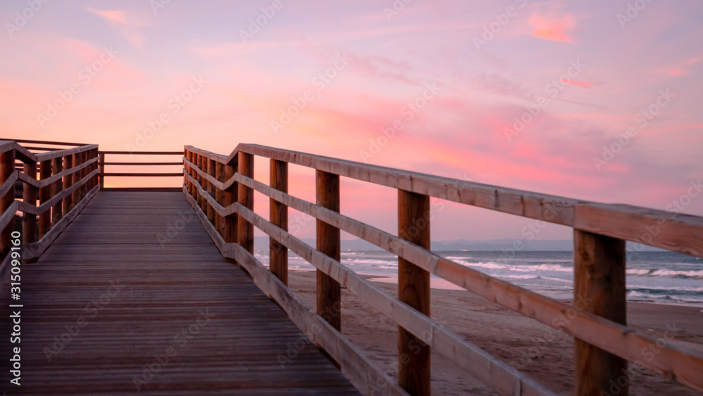 Wild beach with sandy dunes at sunset by the Mediterranean Sea in Valencia Spain