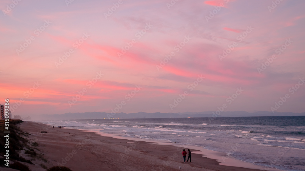 Wild beach with sandy dunes at sunset by the Mediterranean Sea in Valencia Spain Wild beach with sandy dunes at sunset by the Mediterranean Sea in Valencia Spain