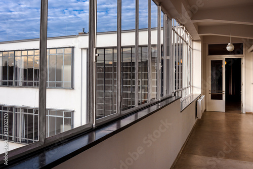 Germany, Saxony-Anhalt, Dessau-Rosslau: Bauhaus building interior view with hallway, famous glass windows, offices and exterior front facade - concept modern architecture art school.