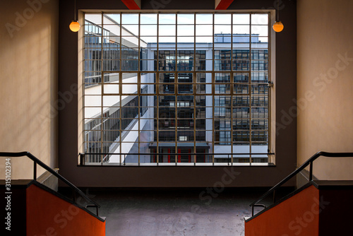 Germany, Saxony-Anhalt, Dessau-Rosslau: Bauhaus building interior view with famous glass windows, stairways stairwell, offices, front facade - concept modern architecture art school.