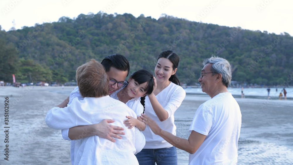 Holiday concept. The big family are happily hugging each other on the beach. 4k Resolution.