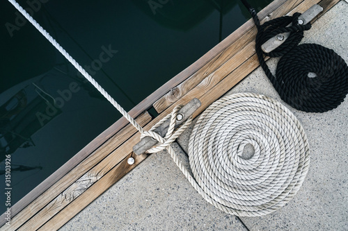 Foto Mooring rope twisted into a spiral on a wharf.