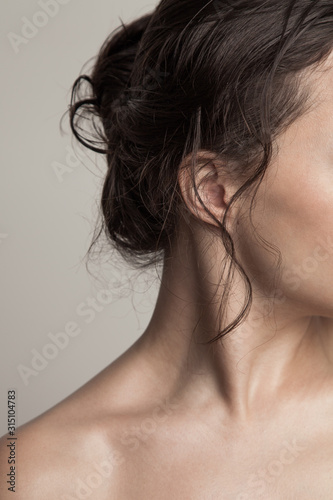 young woman part of face and wet hair in bun close up natural beauty concept studio shot