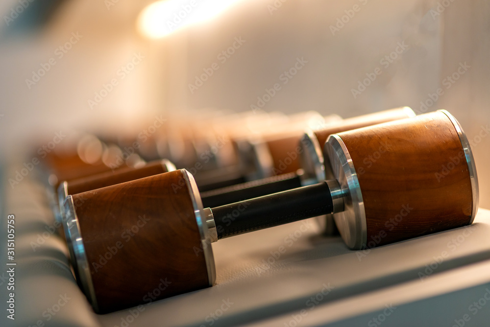 The best for you. Stylish male dumbbells made of wood and steel lying in a row. Sports equipment healthy lifestyle sport. Horizontal shot. Selective focus. Copy space Photos Adobe Stock