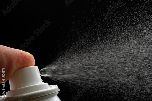spraying water spray or deodorant on a black background