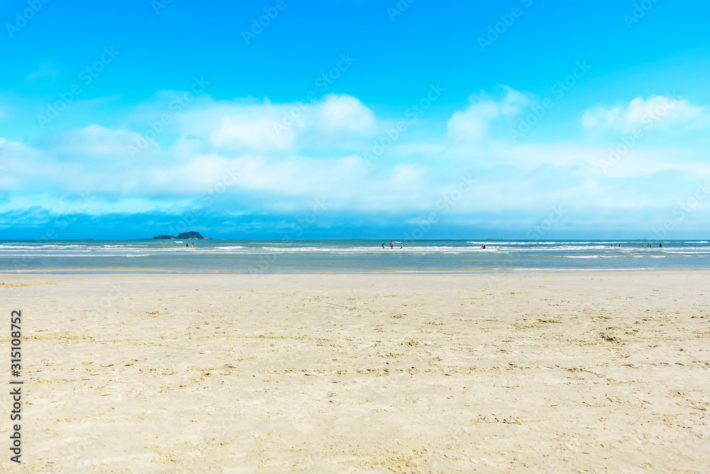 Seascape, beautiful sunny day at the beach. Horizon line on the sea. Brazilian Paulista seacoast, Praia da Enseada beach at Guaruja SP, Brazil.