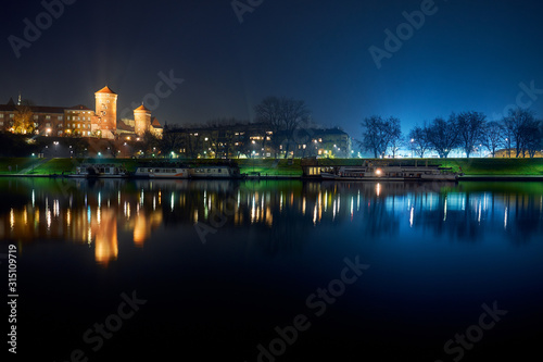 Wawel and embankment at night in Krakow.