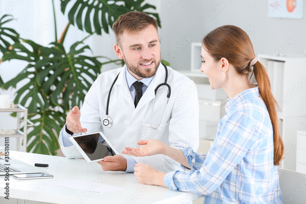 Male doctor working with female patient in clinic Male doctor working with female patient in clinic