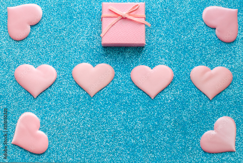 Valentines day pattern background flat lay pink hearts and a pink gift box with rose ribbon on a glittering classic blue background with copy space. love wedding romantic concept, minimal top view Valentines day pattern background flat lay pink hearts and a pink gift box with rose ribbon on a glittering classic blue background with copy space. love wedding romantic concept, minimal top view