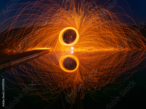 burning steel wool spinning, showers of glowing sparks from spinning steel wool