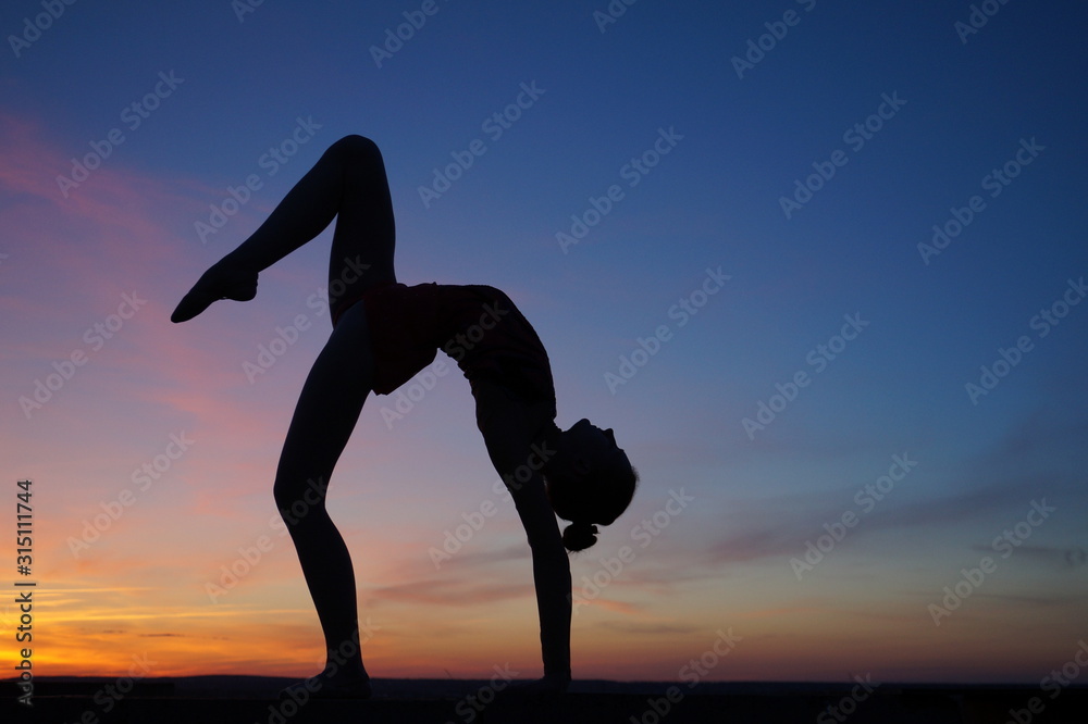 dancer in the dance does the splits in the air against the sunset dancer in the dance does the splits in the air against the sunset