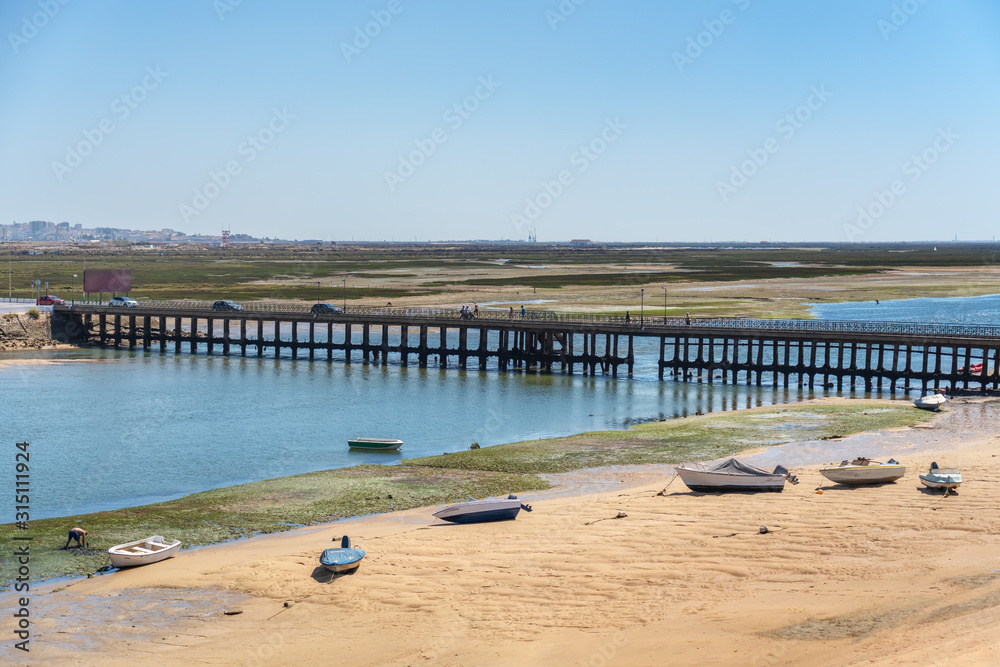 An old bridge on Faro Beach, across the Ria Formosa. Portugal Algarve.
