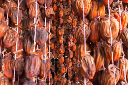 Dried persimmon suspended on a rope, air-drying dried fruits.