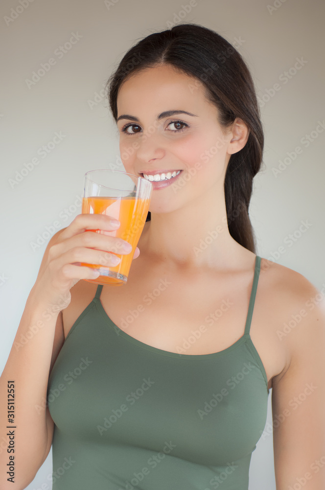 Giovane donna con bicchiere di succo di arancia Giovane donna con bicchiere di succo di arancia