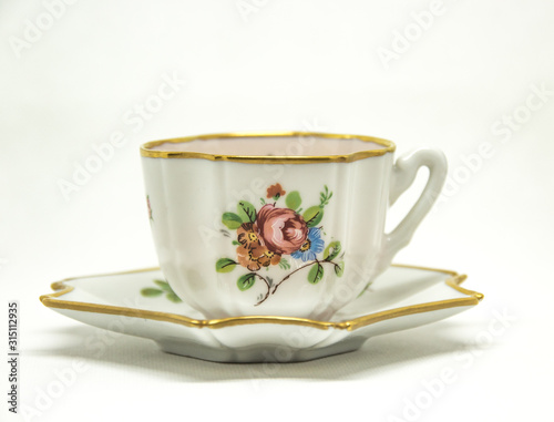ceramic tea cup with floral paintings on a white background