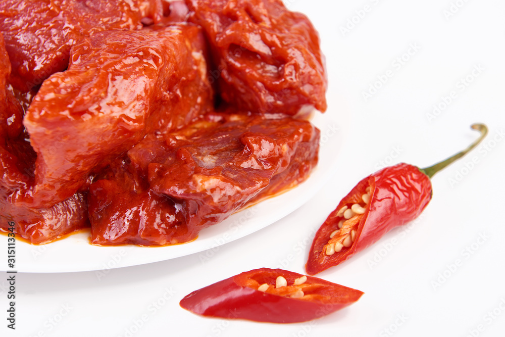 raw meat marinated in spicy sauce close-up, isolated on white background with slices pepper raw meat marinated in spicy sauce close-up, isolated on white background with slices pepper