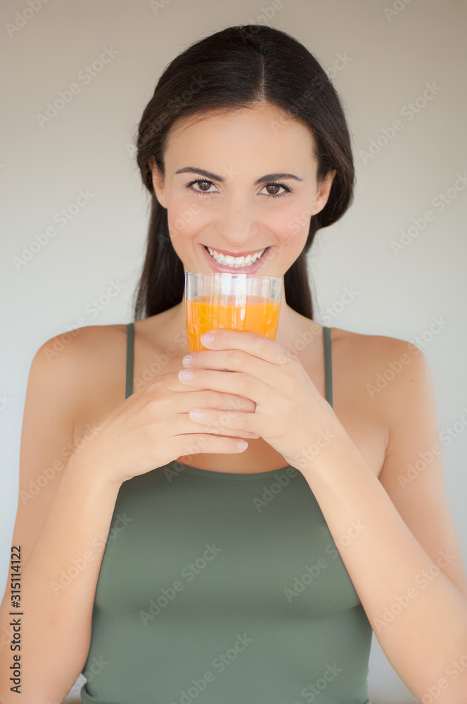 Ragazza tiene un bicchiere di spremuta con due mani Ragazza tiene un bicchiere di spremuta con due mani