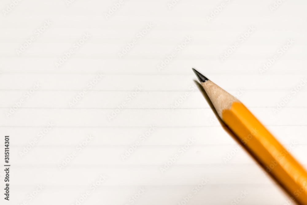 A pencil on clean lined paper. Space for text. A pencil on clean lined paper. Space for text.