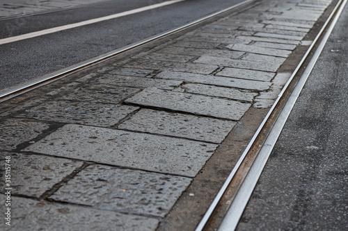 Mixed cobbles pavè and tarmac city road with tramway tracks in Turin Italy
