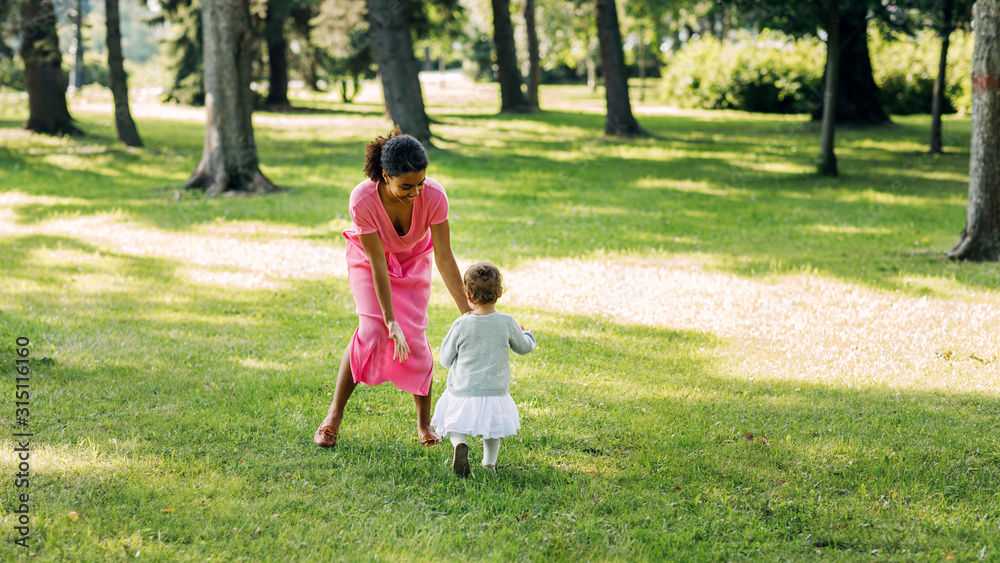Young mother playing in the park with her little daughter Young mother playing in the park with her little daughter