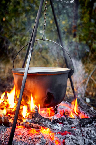 Cooking soup on a campfire in the summer.