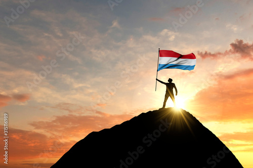 Luxembourg flag being waved at the top of a mountain summit. 3D Rendering