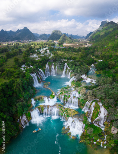 Massive hidden waterfall surrounded by mountain with blue clean water. Paradise on the border between China and Vietnam. Ban gioc waterfall, Detian.