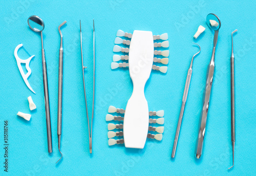 Set of Dentist s medical equipment tools. Stainless steel dental equipment on blue background with copy space.