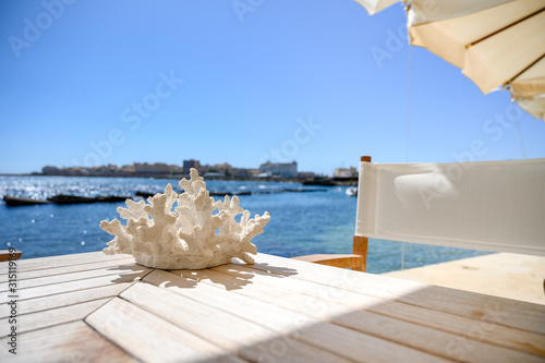 white coral on wooden table on the seashore of Sicily