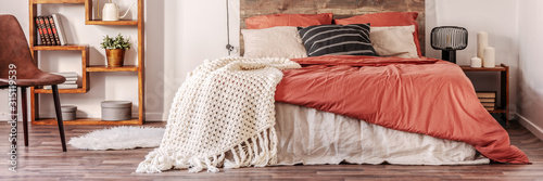Fotografía Panoramic view of trendy bedroom in rustic style with king size bed with dirty o