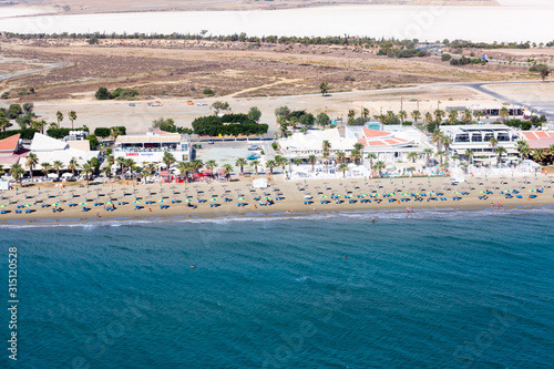 Aerial view at Mackenzie beach with hotel and apartment buildings, sunbeds and umbrellas. It is the beach close to Larnaca International Airport on south of island. Cyprus photo
