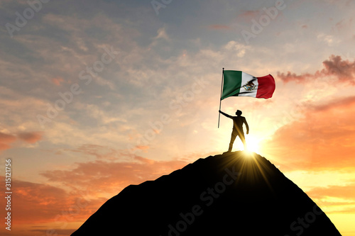Mexican flag being waved at the top of a mountain summit. 3D Rendering photo