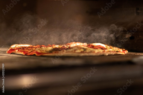 Pizza dans le four avec fumée  photo