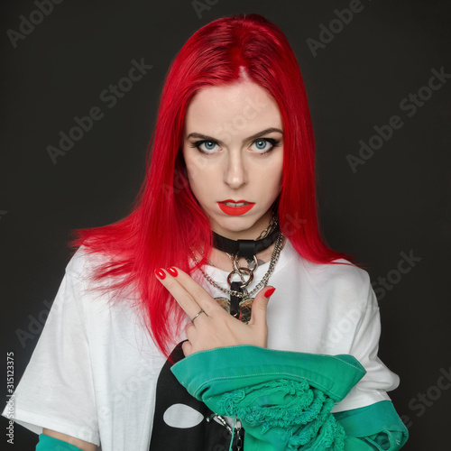 Young beautiful girl with red hair posing in the studio