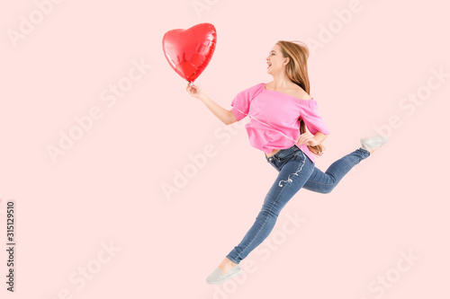 Jumping young woman with ba...