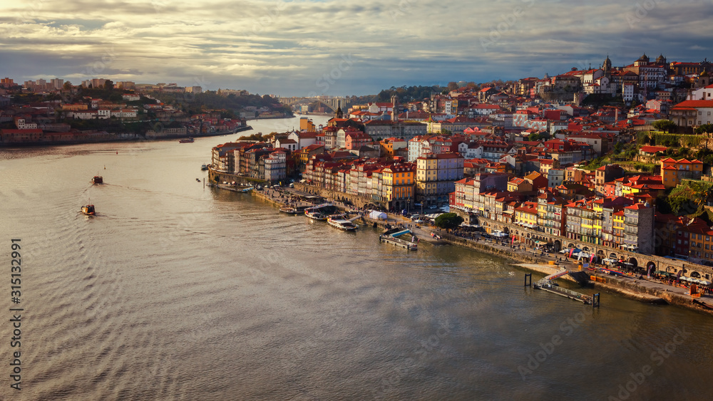 Sunset of traditional boats sailing along the Douro river in Porto