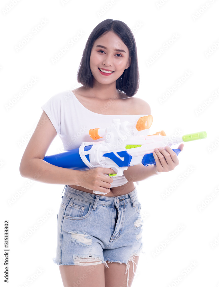 Smiling beautiful Asian girl holding plastic water gun at Songkran festival, Thailand. Modern Beauty fashion women short hair wear White t-shirt happy in Thai ceremony Isolated on white background Smiling beautiful Asian girl holding plastic water gun at Songkran festival, Thailand. Modern Beauty fashion women short hair wear White t-shirt happy in Thai ceremony Isolated on white background
