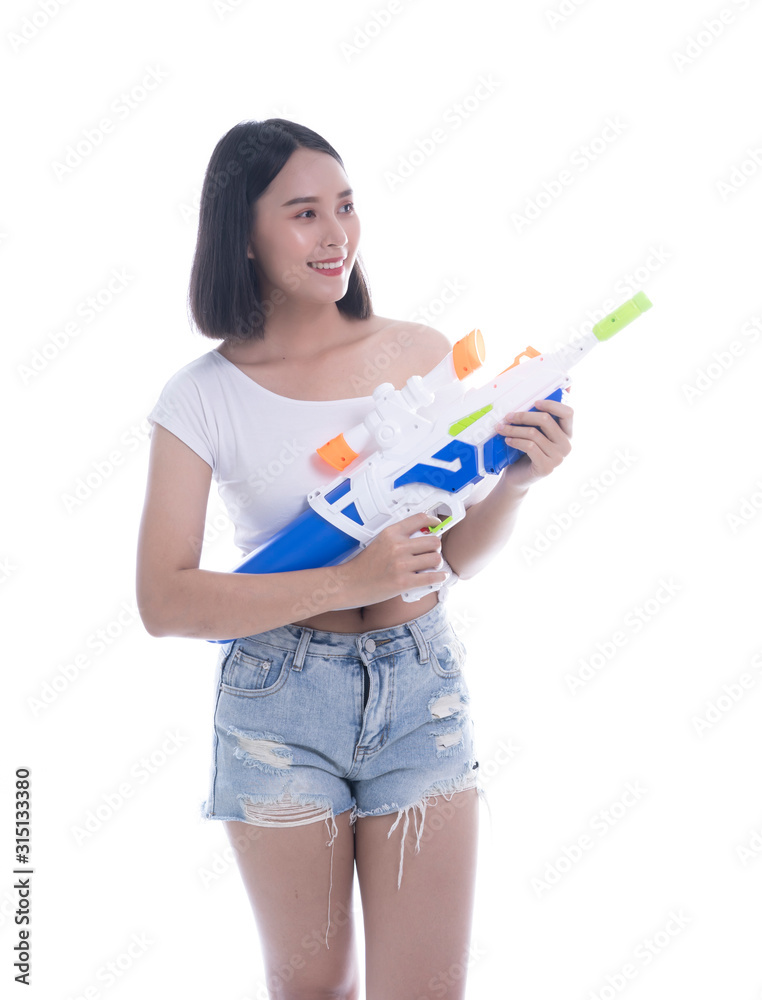 Smiling beautiful Asian girl holding plastic water gun at Songkran festival, Thailand. Modern Beauty fashion women short hair wear White t-shirt happy in Thai ceremony Isolated on white background Smiling beautiful Asian girl holding plastic water gun at Songkran festival, Thailand. Modern Beauty fashion women short hair wear White t-shirt happy in Thai ceremony Isolated on white background
