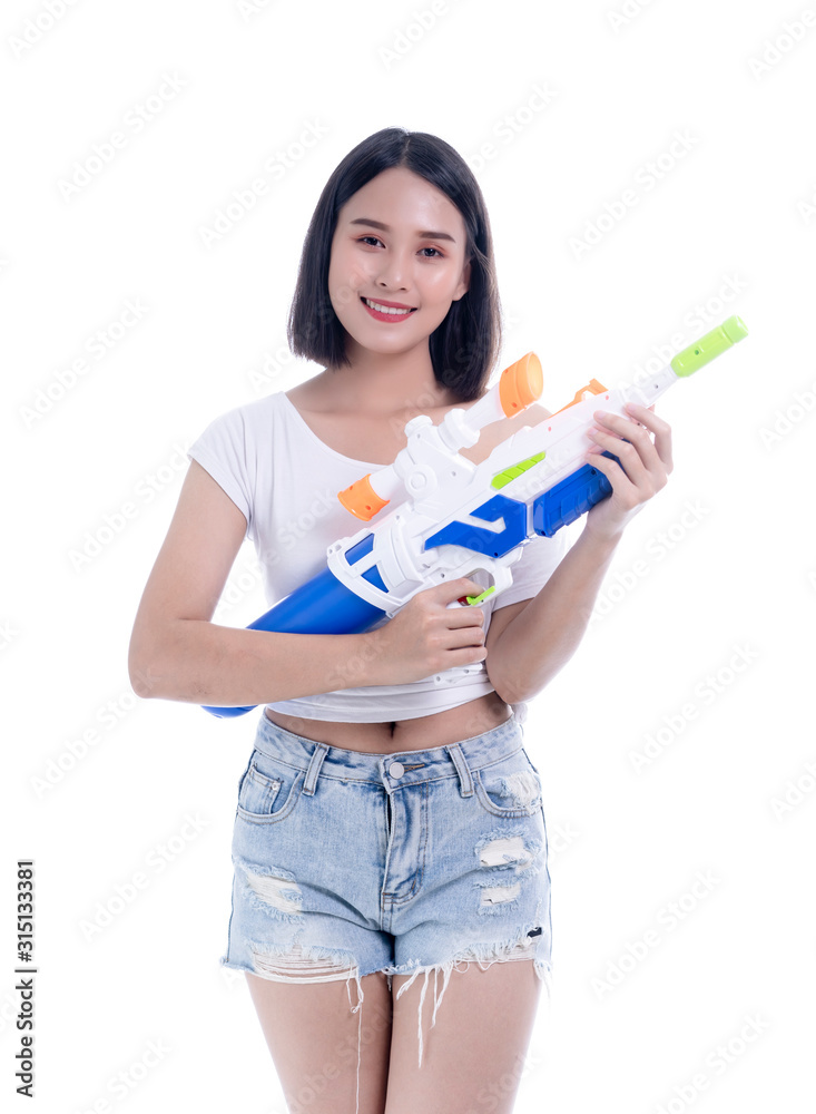 Smiling beautiful Asian girl holding plastic water gun at Songkran festival, Thailand. Modern Beauty fashion women short hair wear White t-shirt happy in Thai ceremony Isolated on white background Smiling beautiful Asian girl holding plastic water gun at Songkran festival, Thailand. Modern Beauty fashion women short hair wear White t-shirt happy in Thai ceremony Isolated on white background