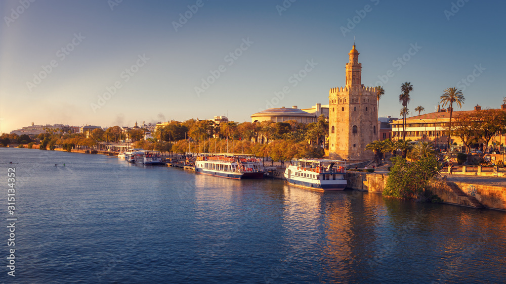 Torre del Oro (Tower of Gold), with sunset lights, on the Guadalquivir riverbed, Seville, Spain