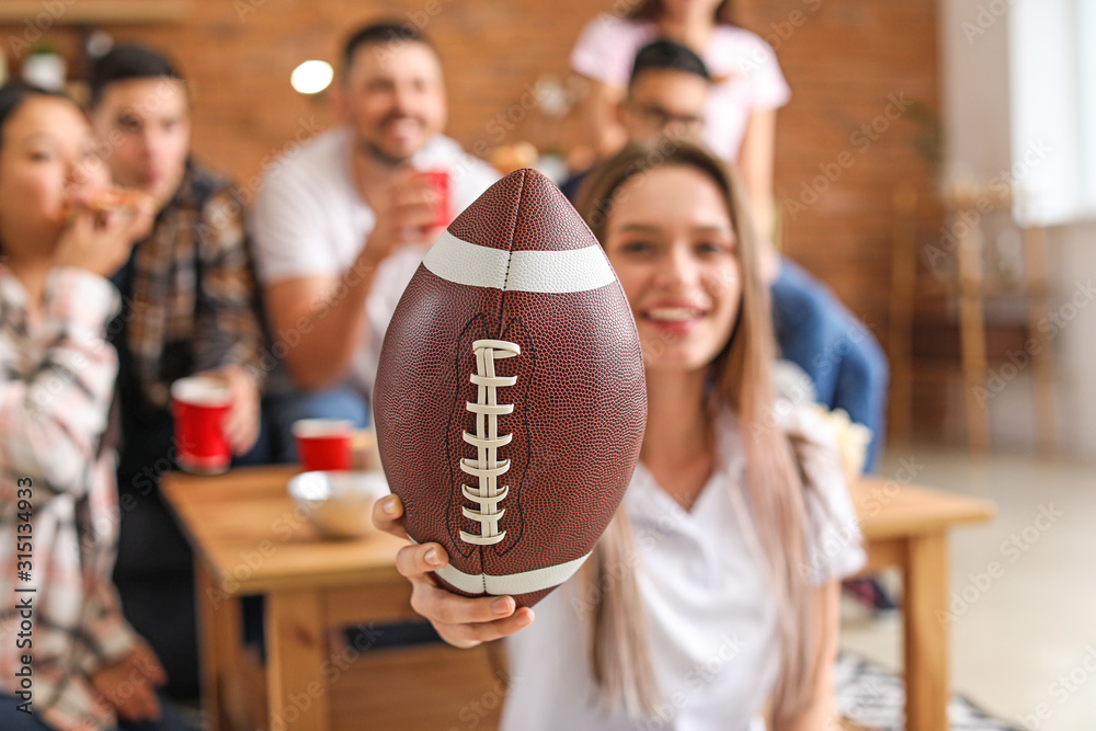 Young woman with friends watching rugby on TV - obrazy, fototapety, plakaty 