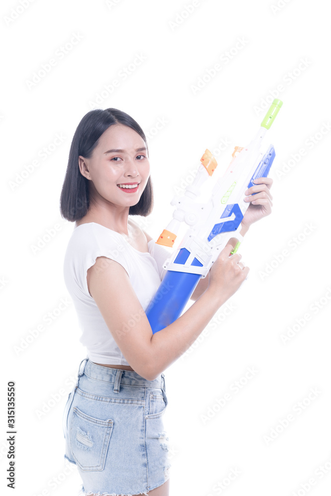 Smiling beautiful Asian girl holding plastic water gun at Songkran festival, Thailand. Modern Beauty fashion women short hair wear White t-shirt happy in Thai ceremony Isolated on white background Smiling beautiful Asian girl holding plastic water gun at Songkran festival, Thailand. Modern Beauty fashion women short hair wear White t-shirt happy in Thai ceremony Isolated on white background