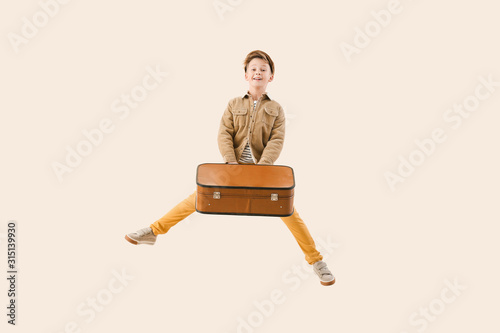 Jumping little boy with sui...