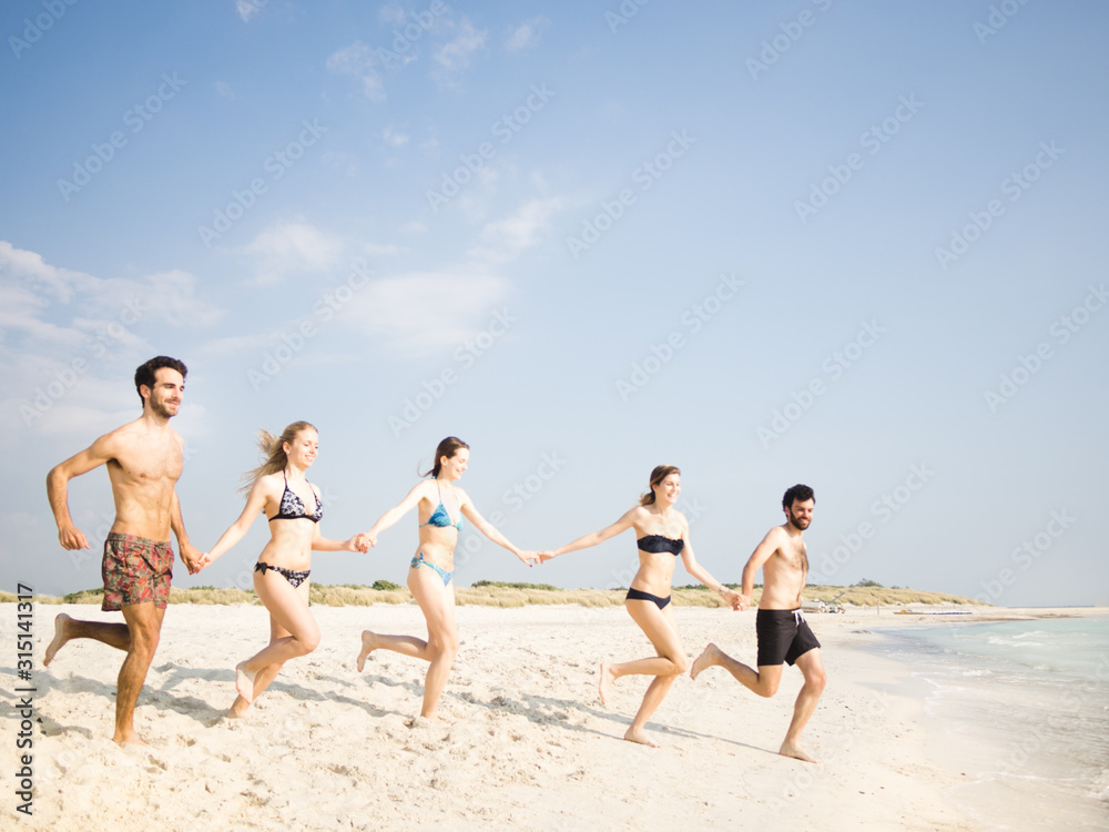 Group of friends running to the water