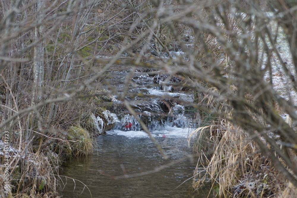 Kleiner Wasserfall im Winter am Alpenrand