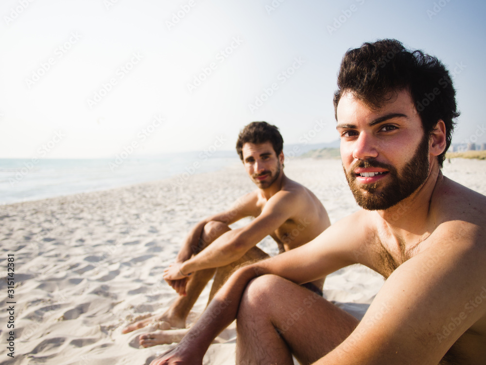 Fototapeta premium Two friends seating on the beach together