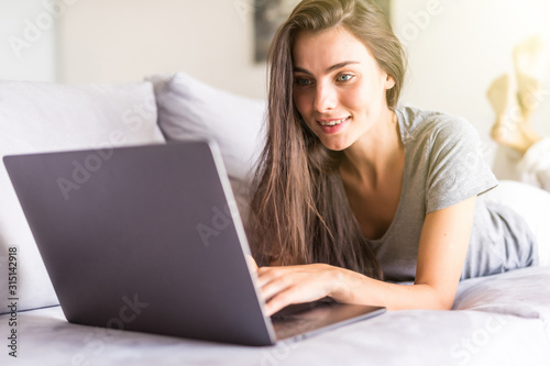 Young woman using a laptop while relaxing on the couch